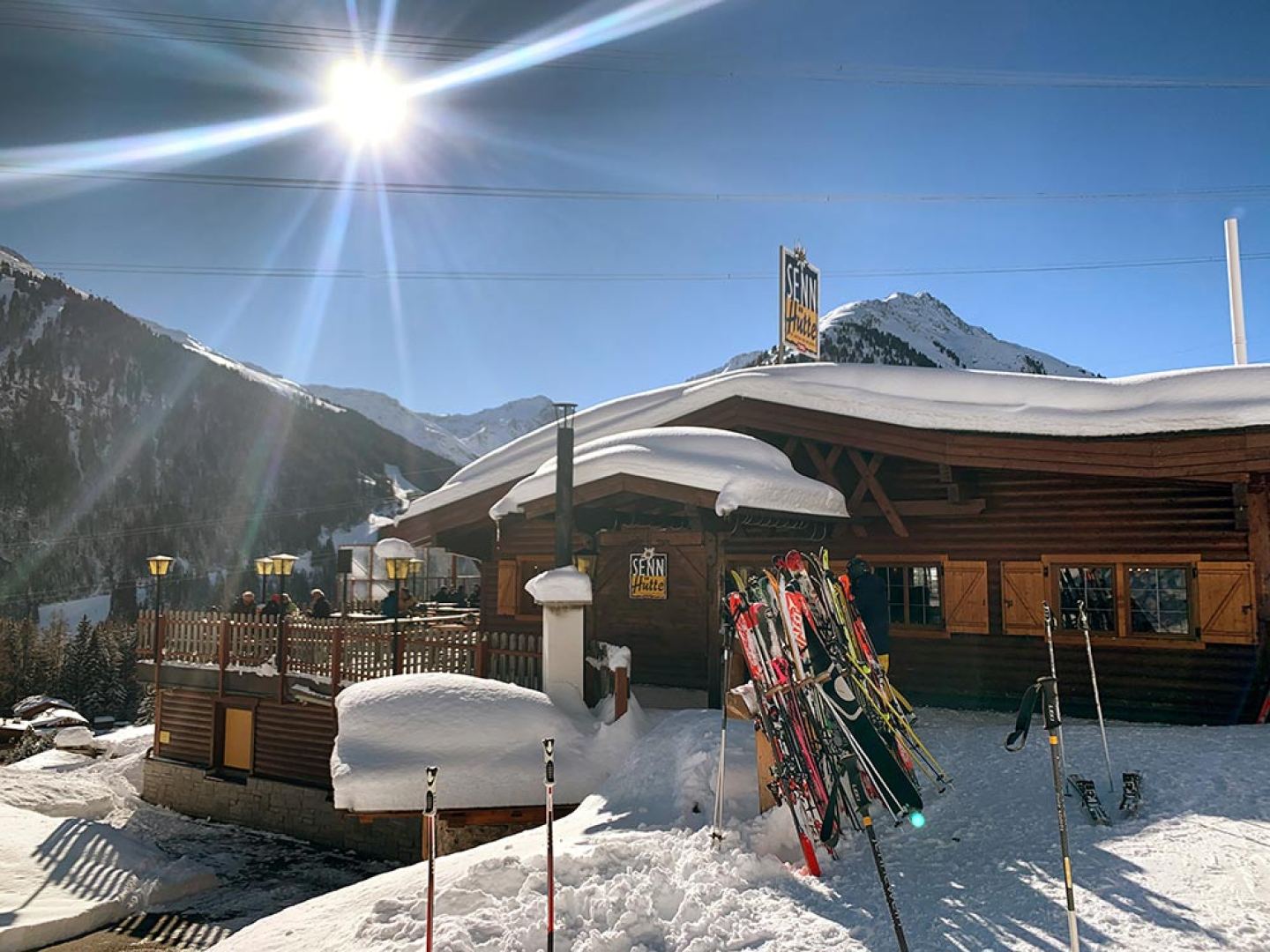 Sennhütte am Arlberg im Winter mit Skiern in der Sonne
