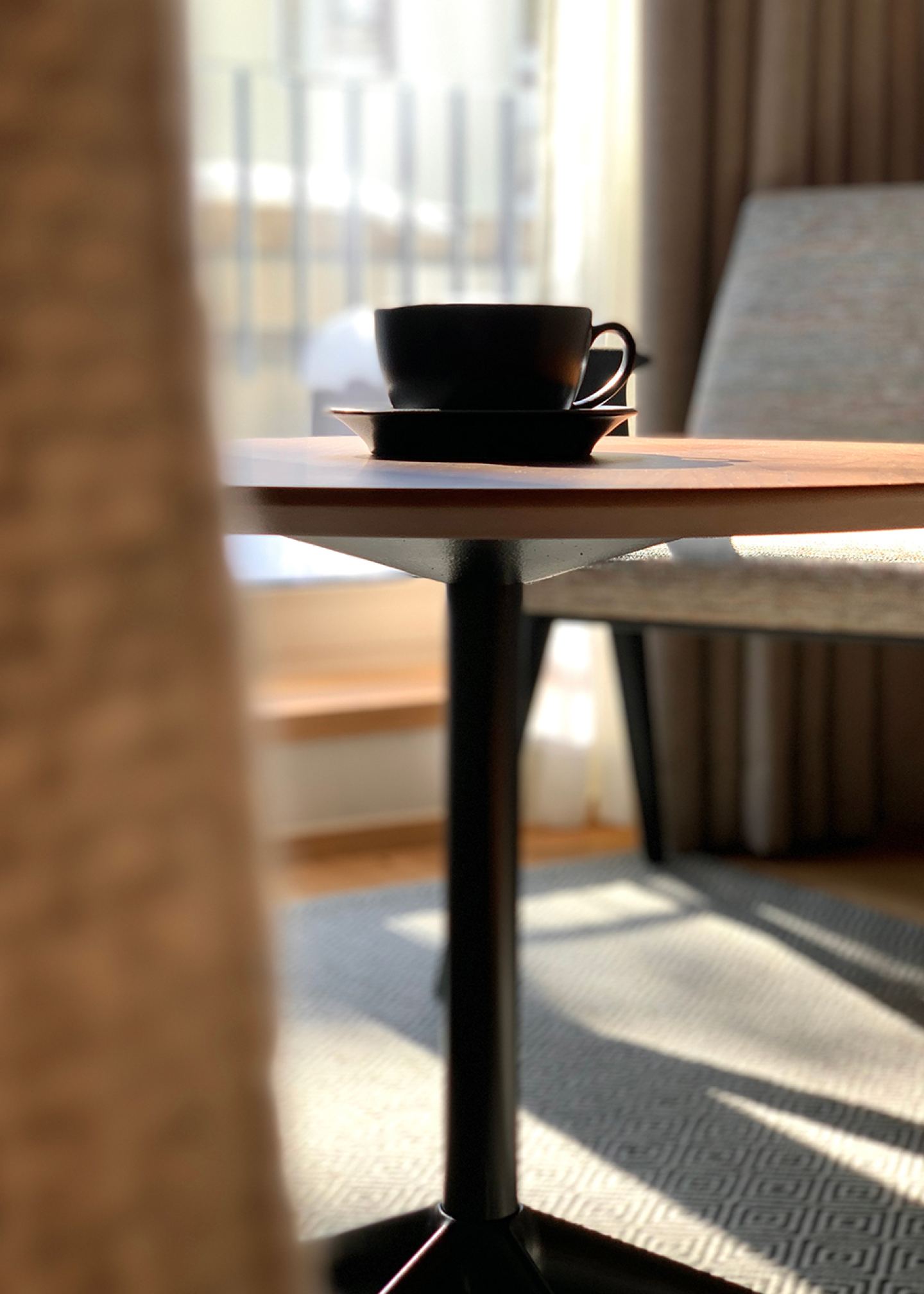 Espresso on the side table in a sunlit Omaela apartment
