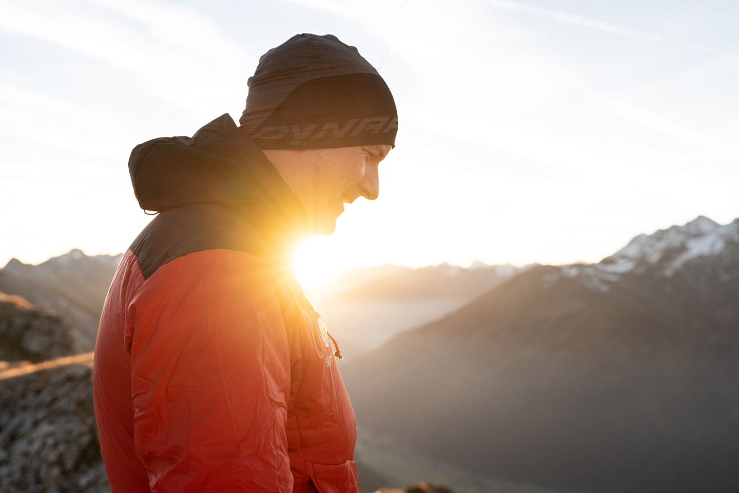 Wanderer im Gegenlicht am Berggipfel bei Sonnenaufgang am Arlberg