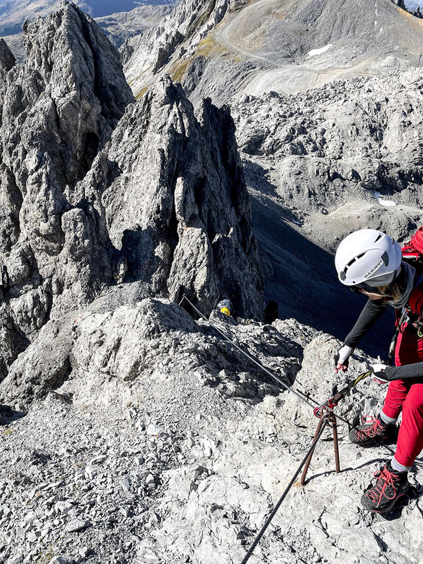 Via ferrata climber with helmet and a deep view over the rocky Arlberg peaks