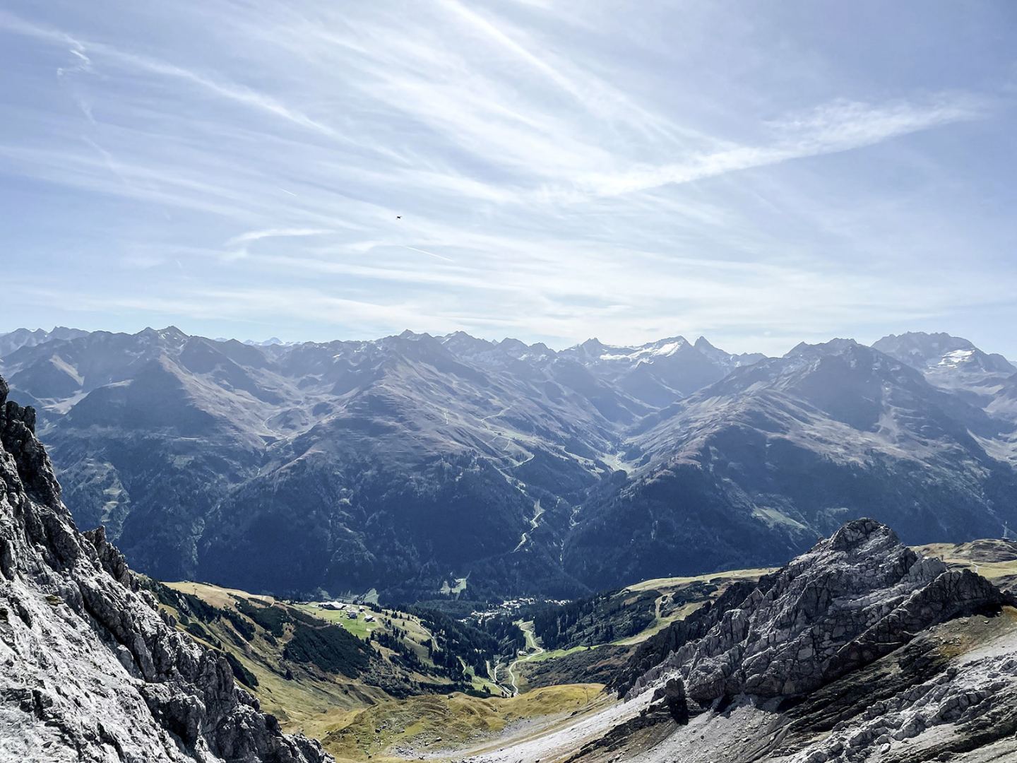 Mountain panorama over the green valley from a rocky summit on the Arlberg