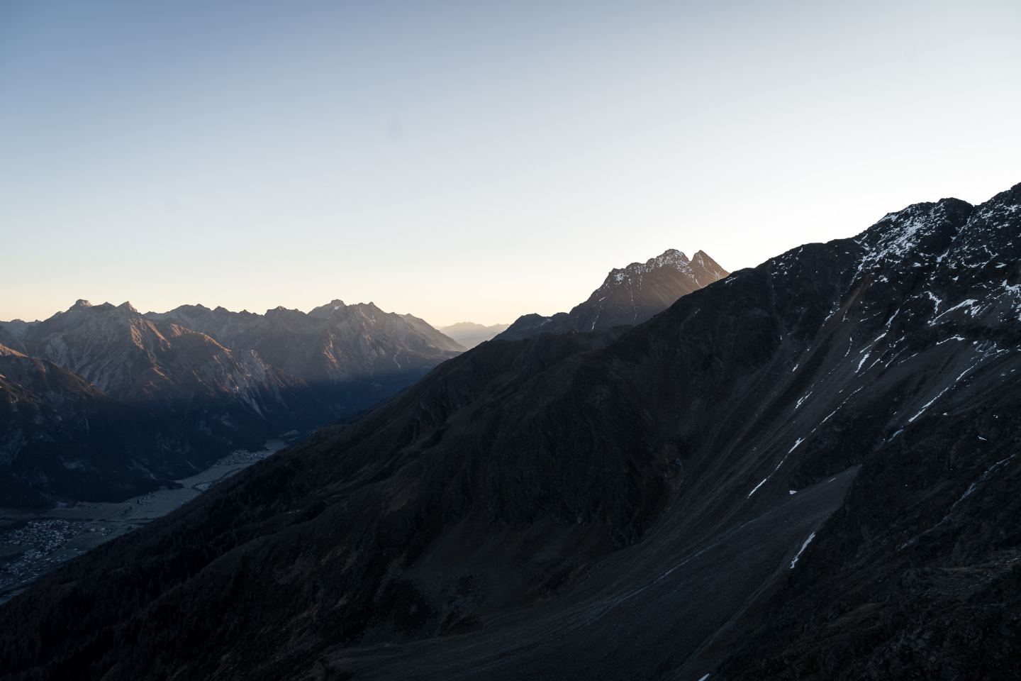 Mountain silhouettes with valley and village at dawn on the Arlberg