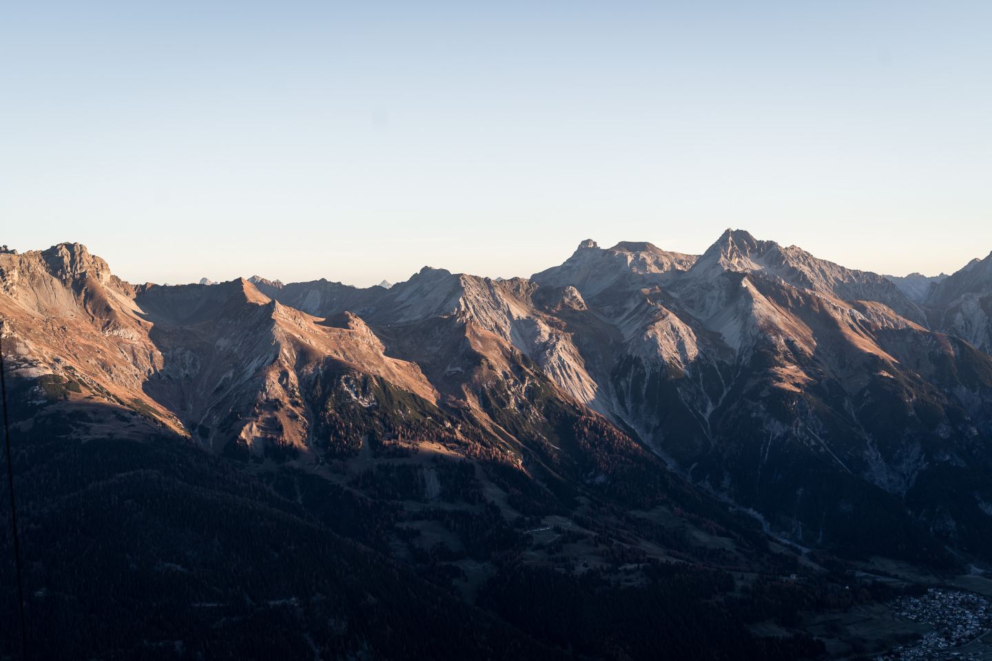 Wide mountain panorama with rocky peaks in golden morning light above the valley on the Arlberg