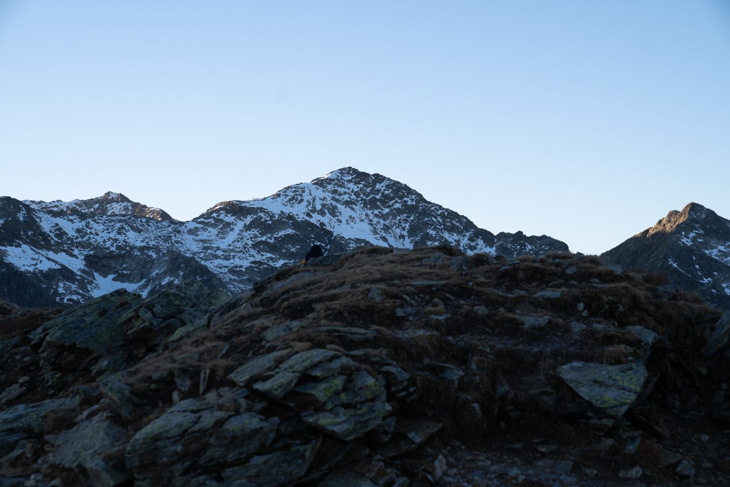 Snow-covered peak above a rocky ridge at dawn on the Arlberg