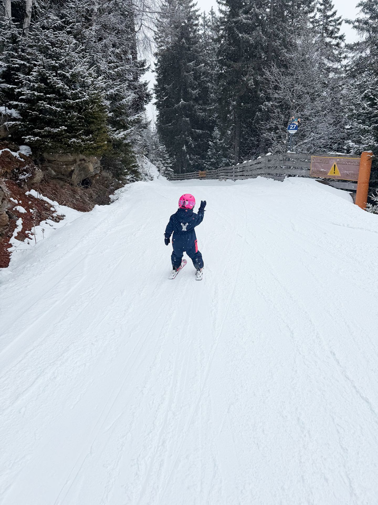 Kind im rosa Helm beim Skifahren auf der verschneiten Übungspiste am Hopplweg, St. Anton am Arlberg