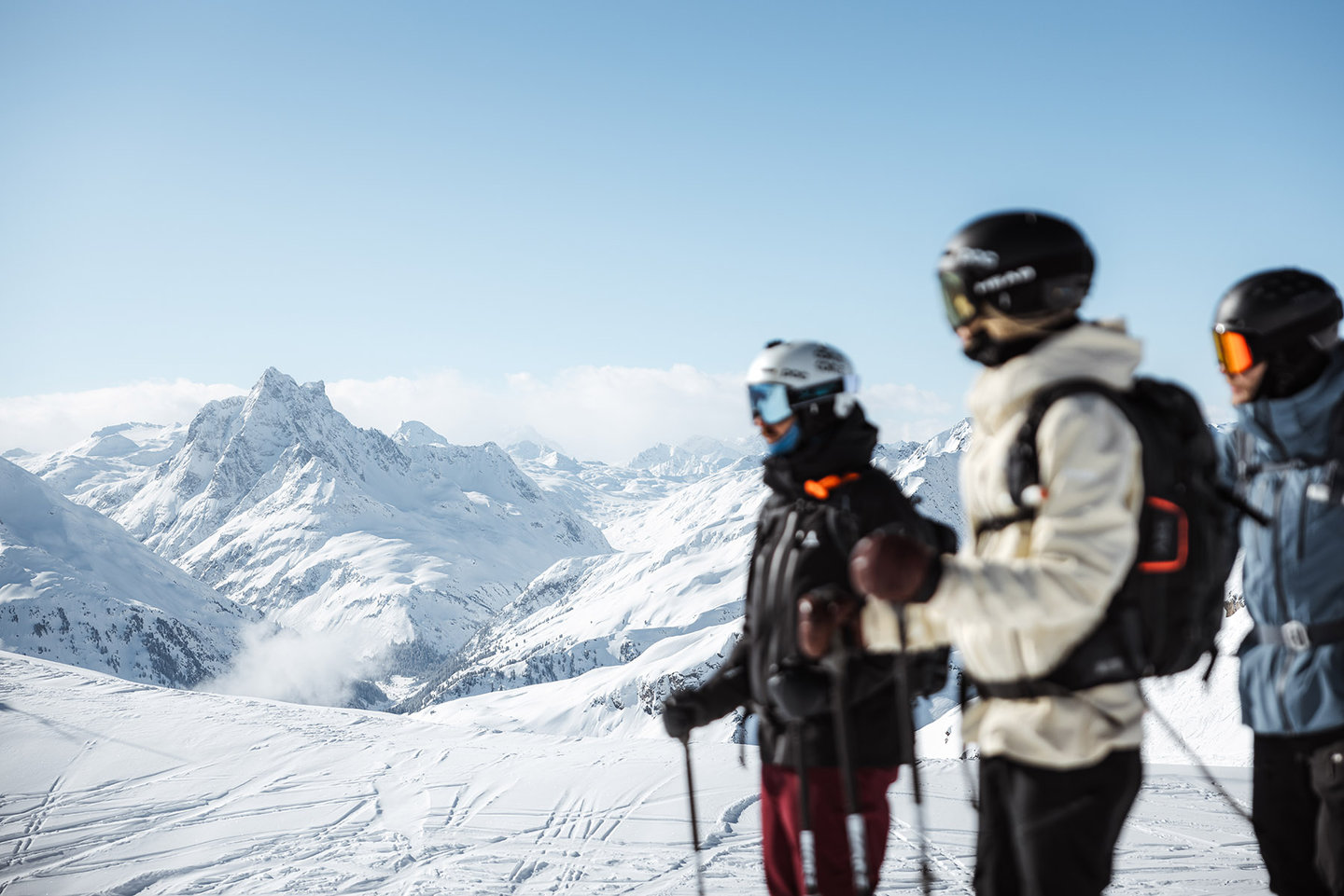 Drei Freerider blicken über das verschneite Bergpanorama am Arlberg