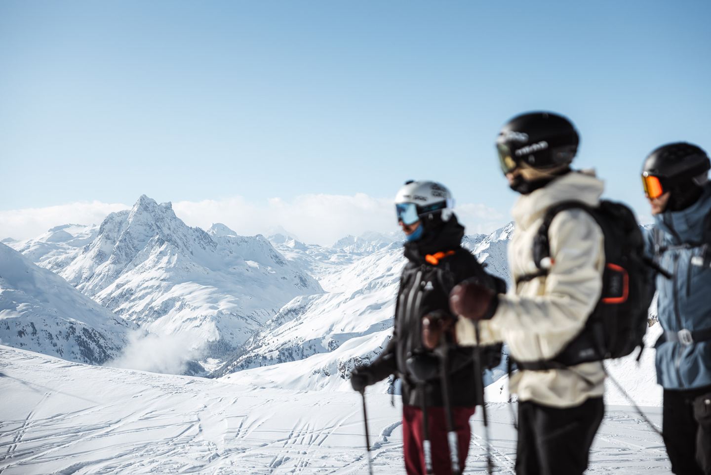 Drei Freerider blicken über das verschneite Bergpanorama am Arlberg